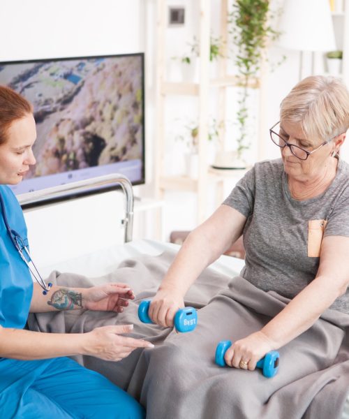 Health visitor helping old woman in nursing home